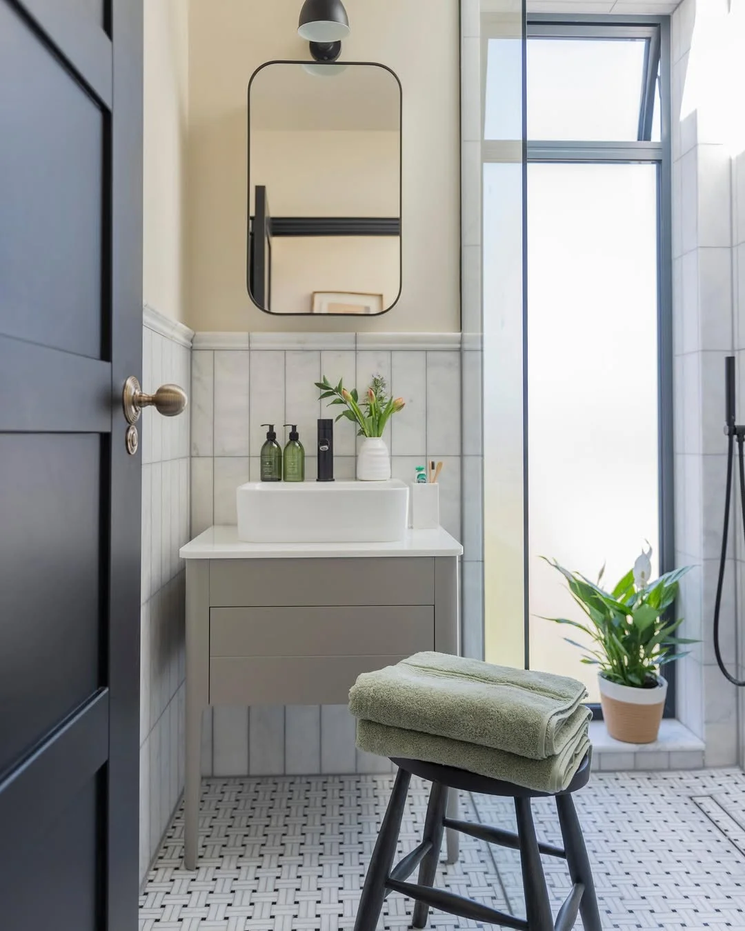 Modern Bathroom with Black Framed Mirror and Sconce