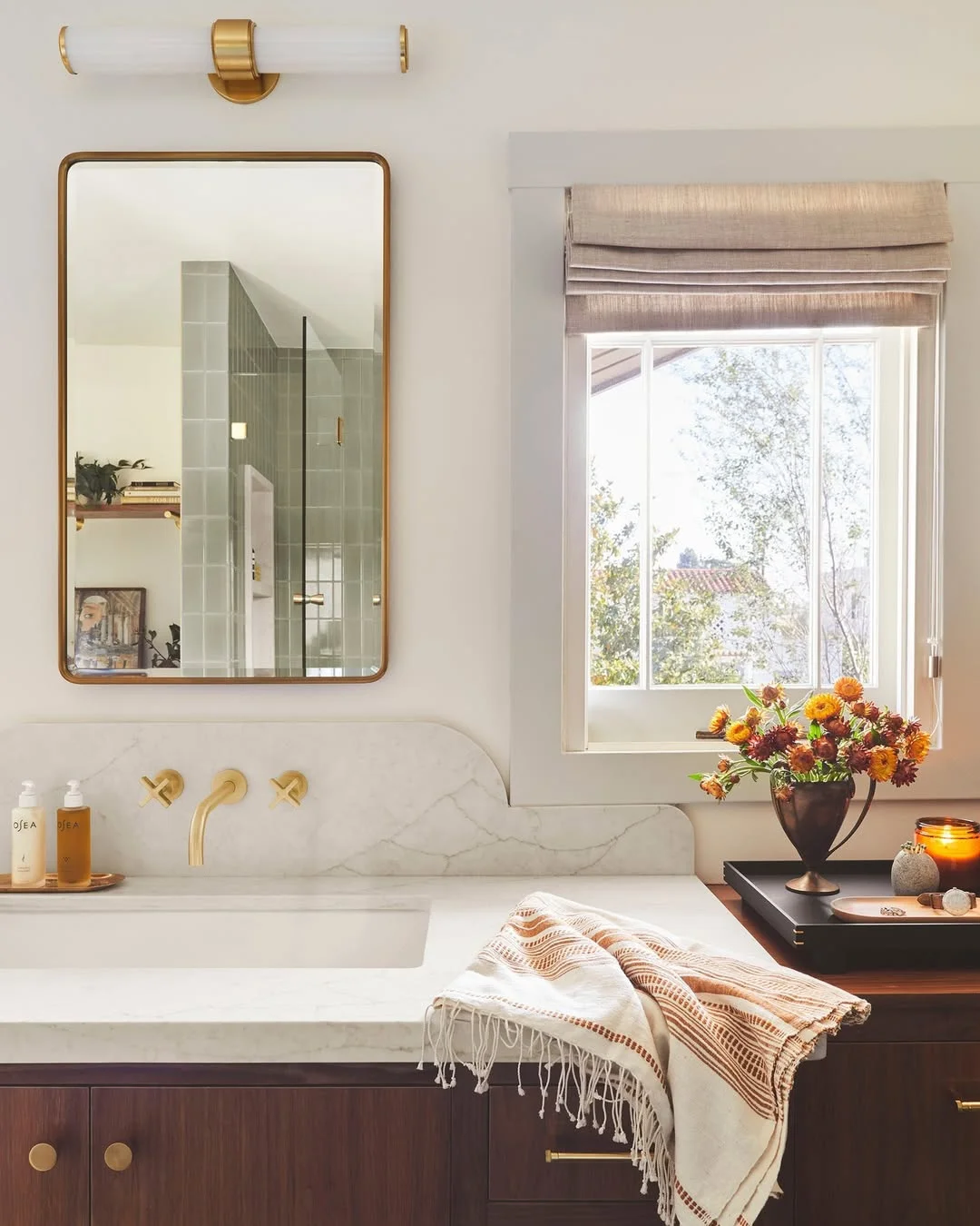 Warm and Inviting Bathroom with Gold Sconce and Mirror