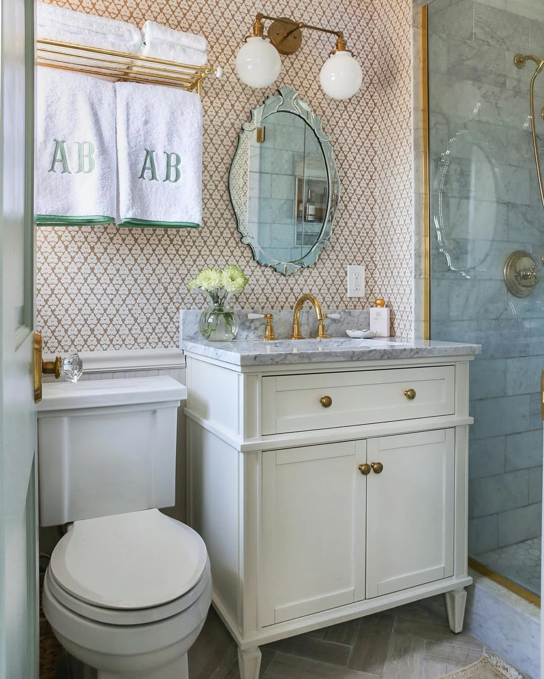 Elegant Small Bathroom with Globe Sconce and Ornate Mirror