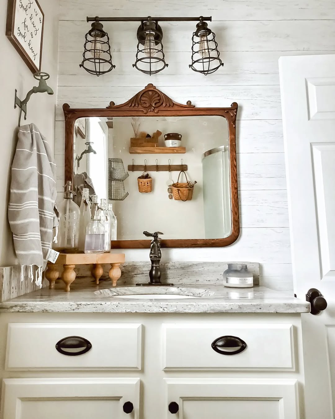 Rustic Bathroom with Industrial Cage Lights and Antique Mirror