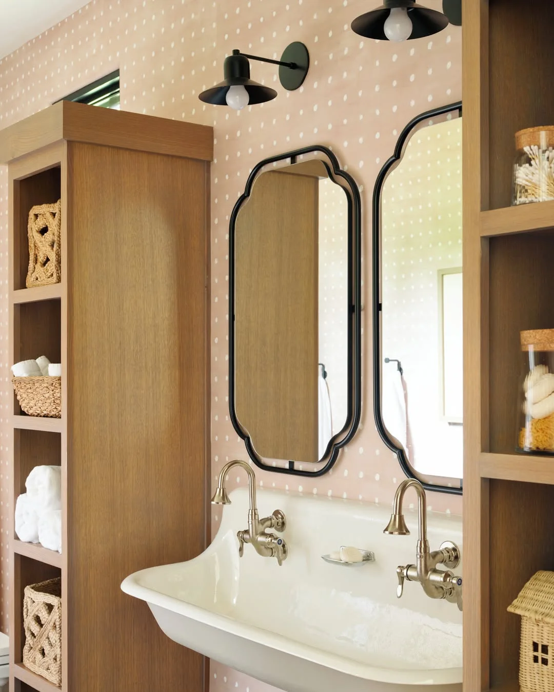 Whimsical Bathroom with Polka Dot Walls and Black Mirror Lights