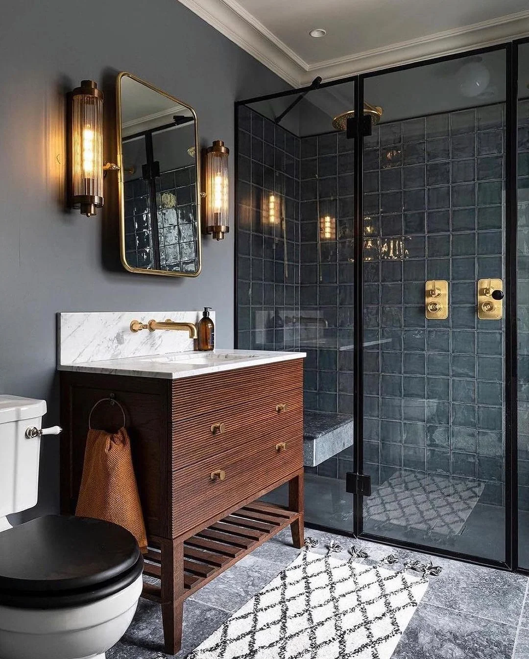 Moody Bathroom with Dark Tile and Brass Accents