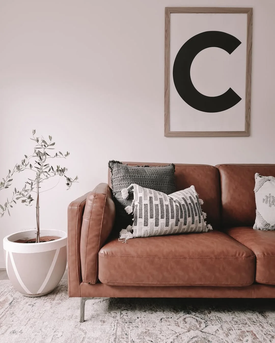 Minimalist Living Room with Tan Leather Sofa and Olive Tree