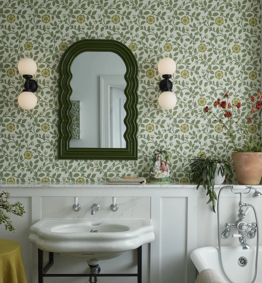 Green and White Bathroom with Floral Wallpaper and Scalloped Mirror