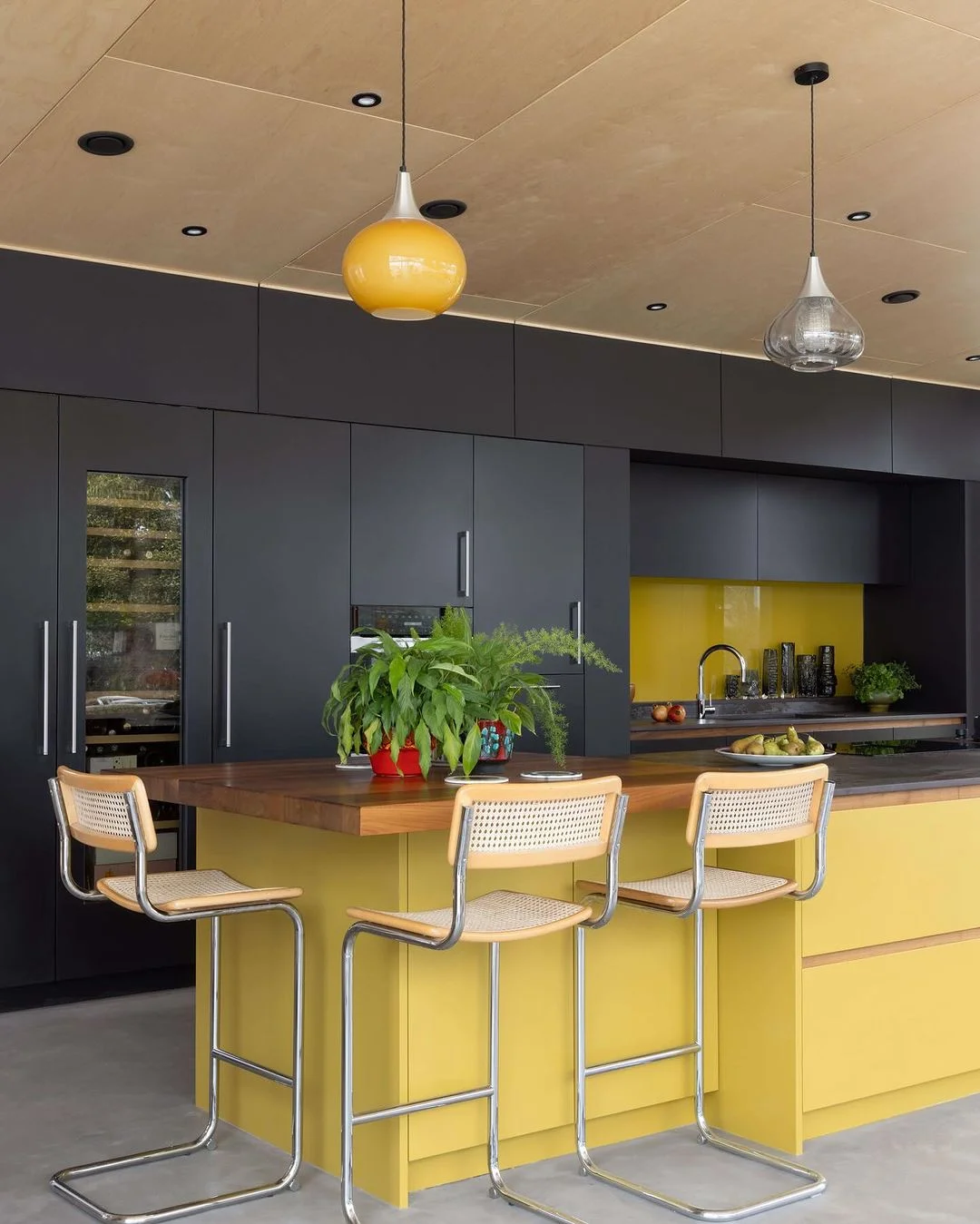 Sleek Yellow Island with Dramatic Dark Cabinets